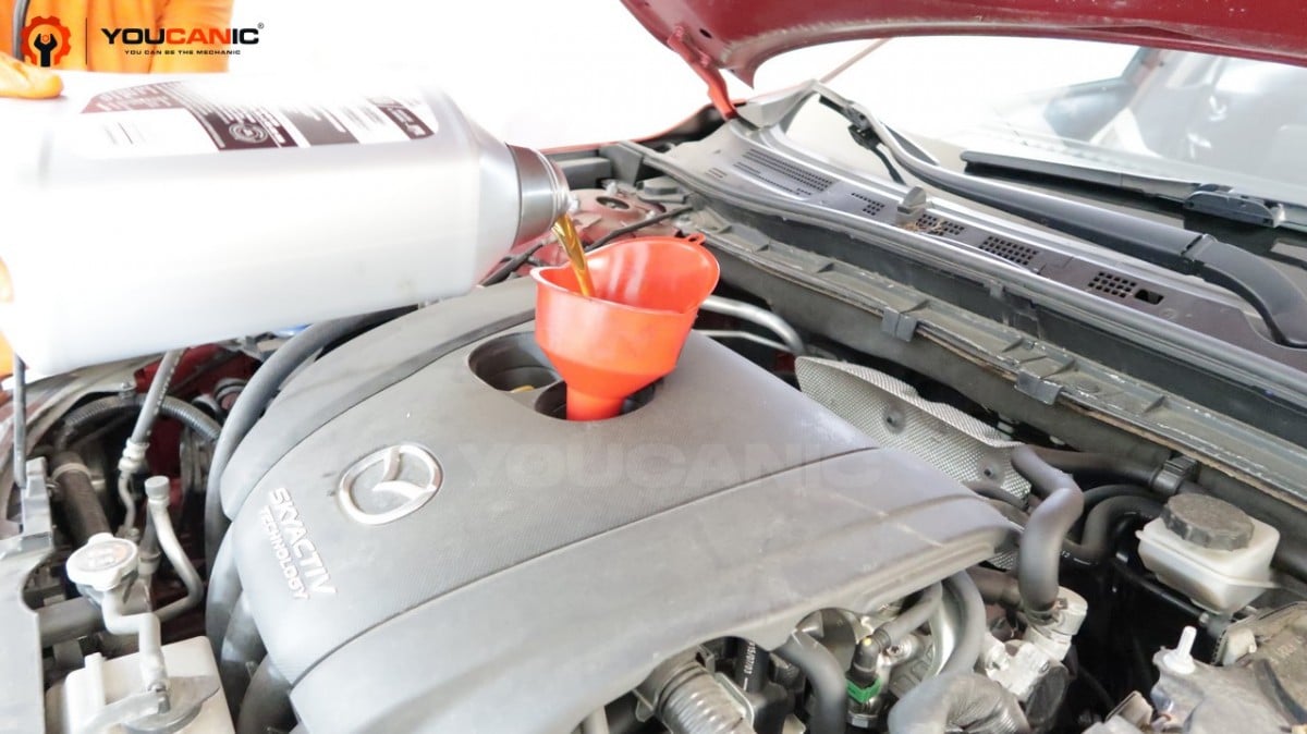 Adding engine oil to the Mazda 3.