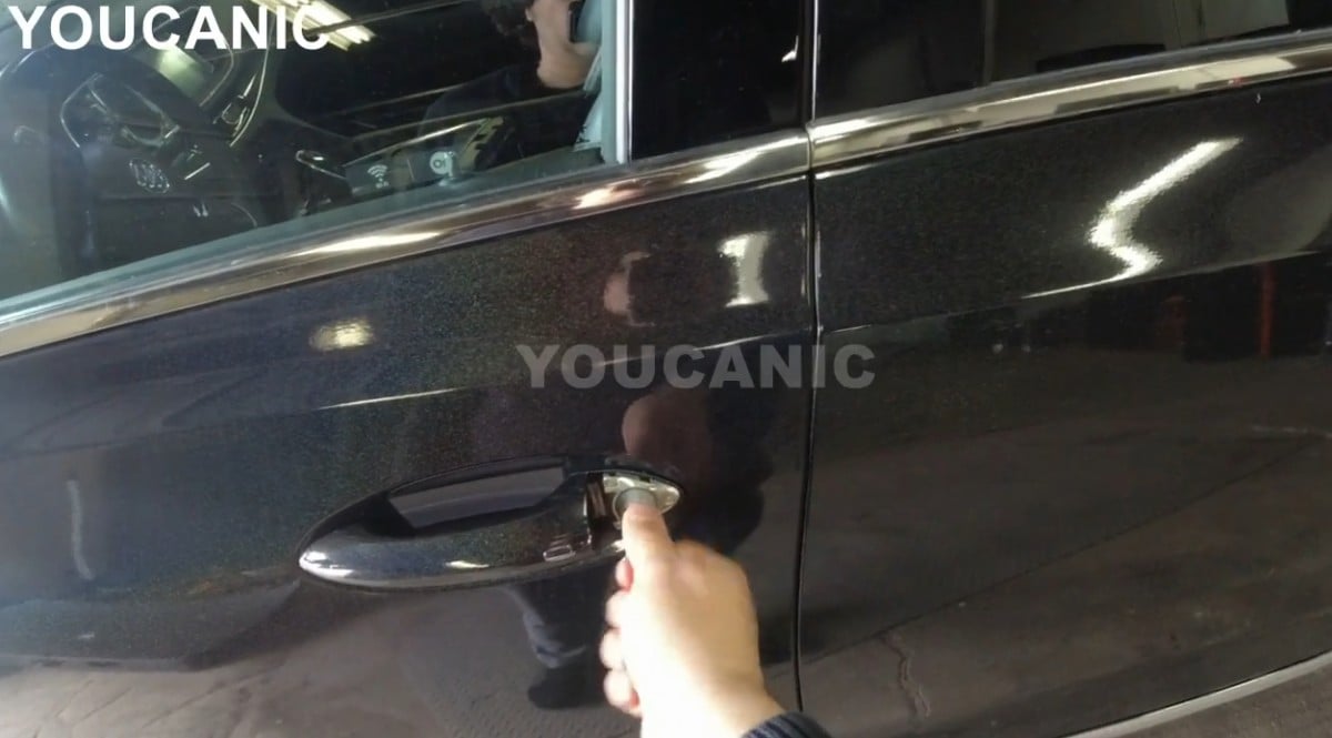 Inserting the metal key to the lock on the driver's door.