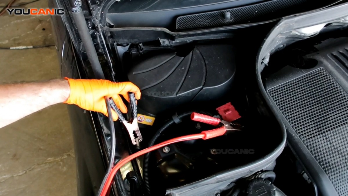 Connecting the black jumper cable to the negative/ground terminal of the battery.