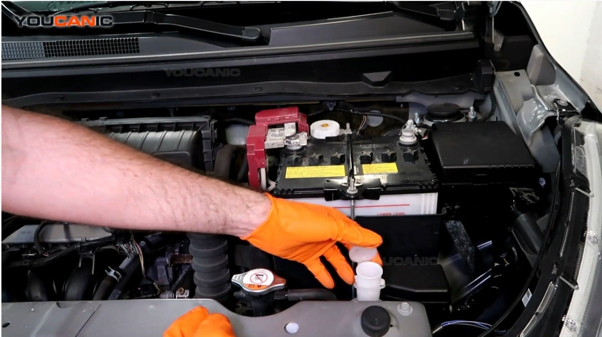 Opening the engine coolant reservoir of the Mitsubishi Mirage.