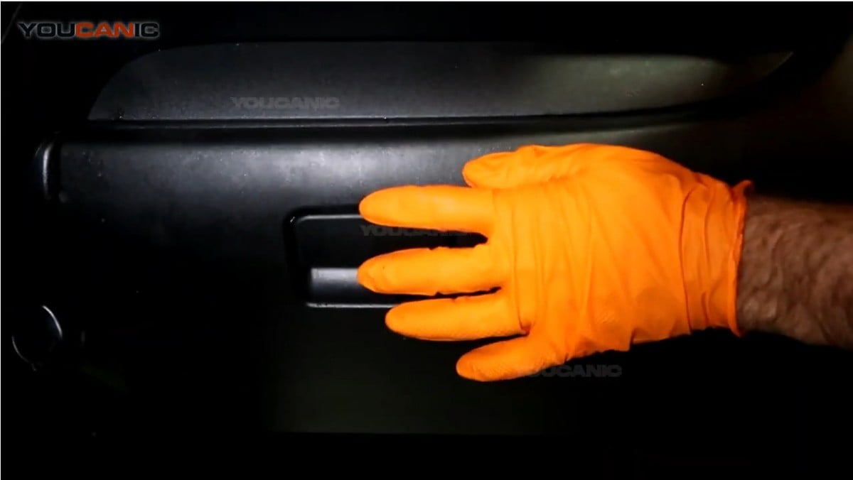 Pushing the glove box in to lock the tabs on the glove box.