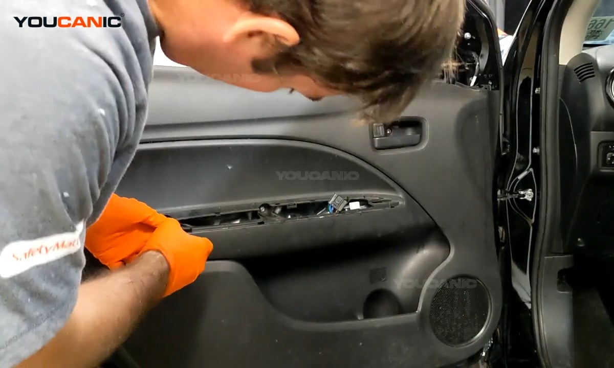 Reinstalling the screws to the armrest of the door panel.
