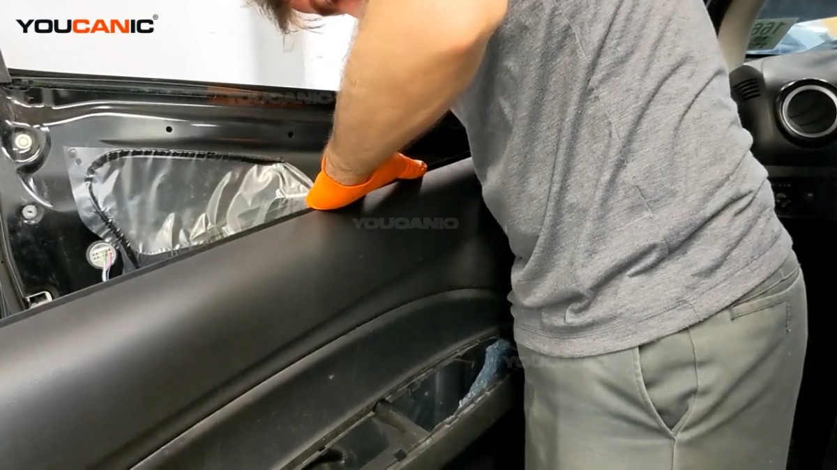 Reinstalling the door panel of the Mitsubishi Mirage.
