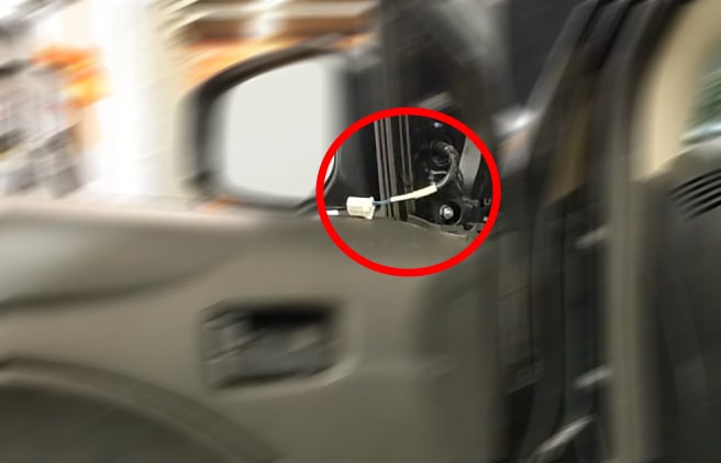 Disconnecting the side mirror cable.