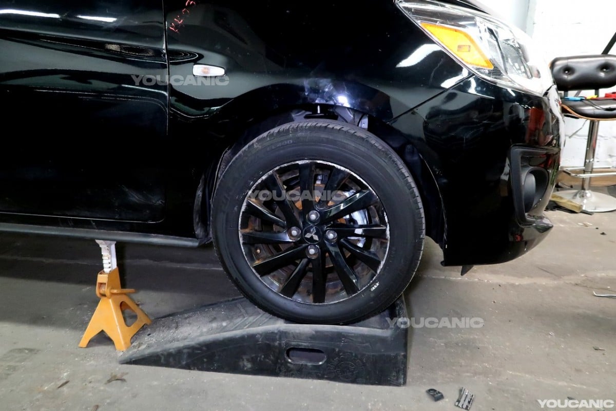 Reinstalling the front wheel of the Mitsubishi Mirage.