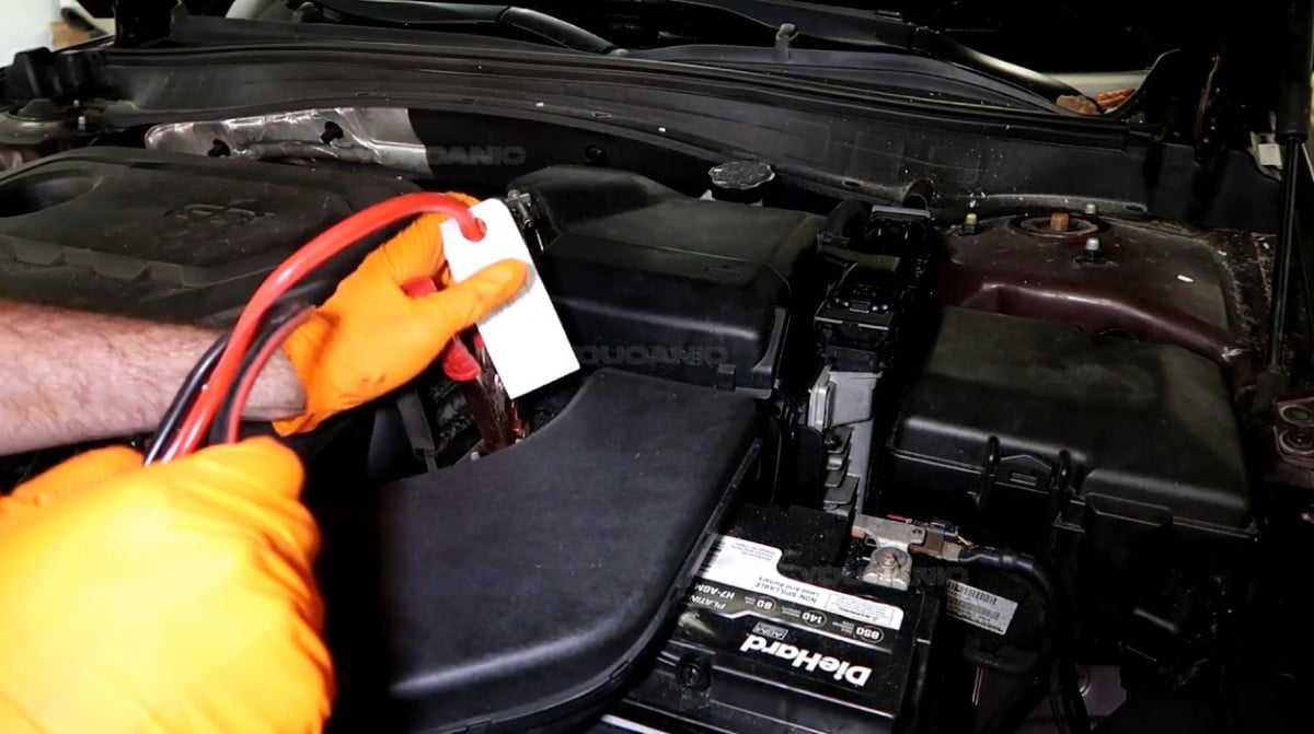 Connecting the positive jumper cable to the positive terminal of the battery