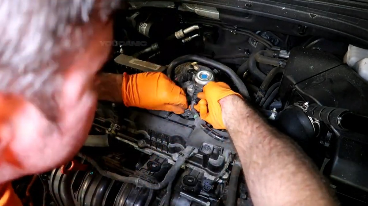 Disconnecting the electrical connector from the ignition coil.