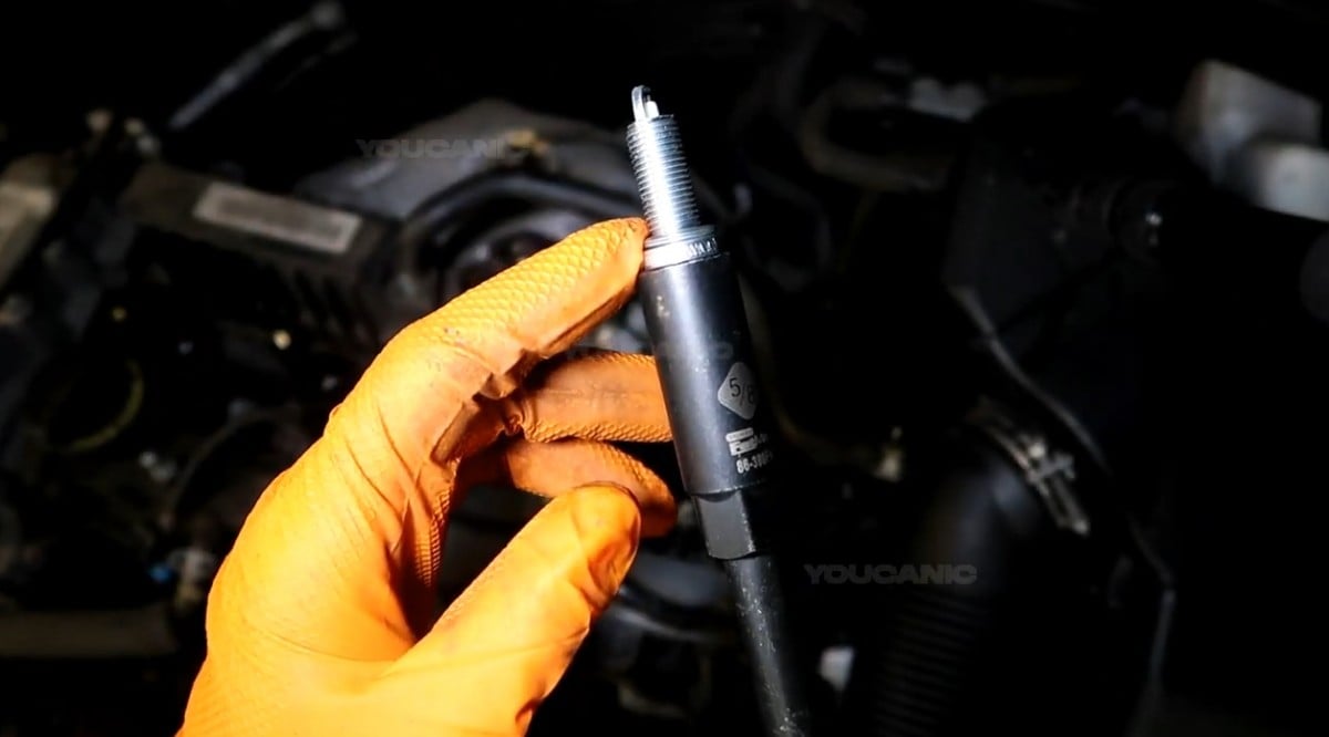 Installing the new spark plug of the vehicle.