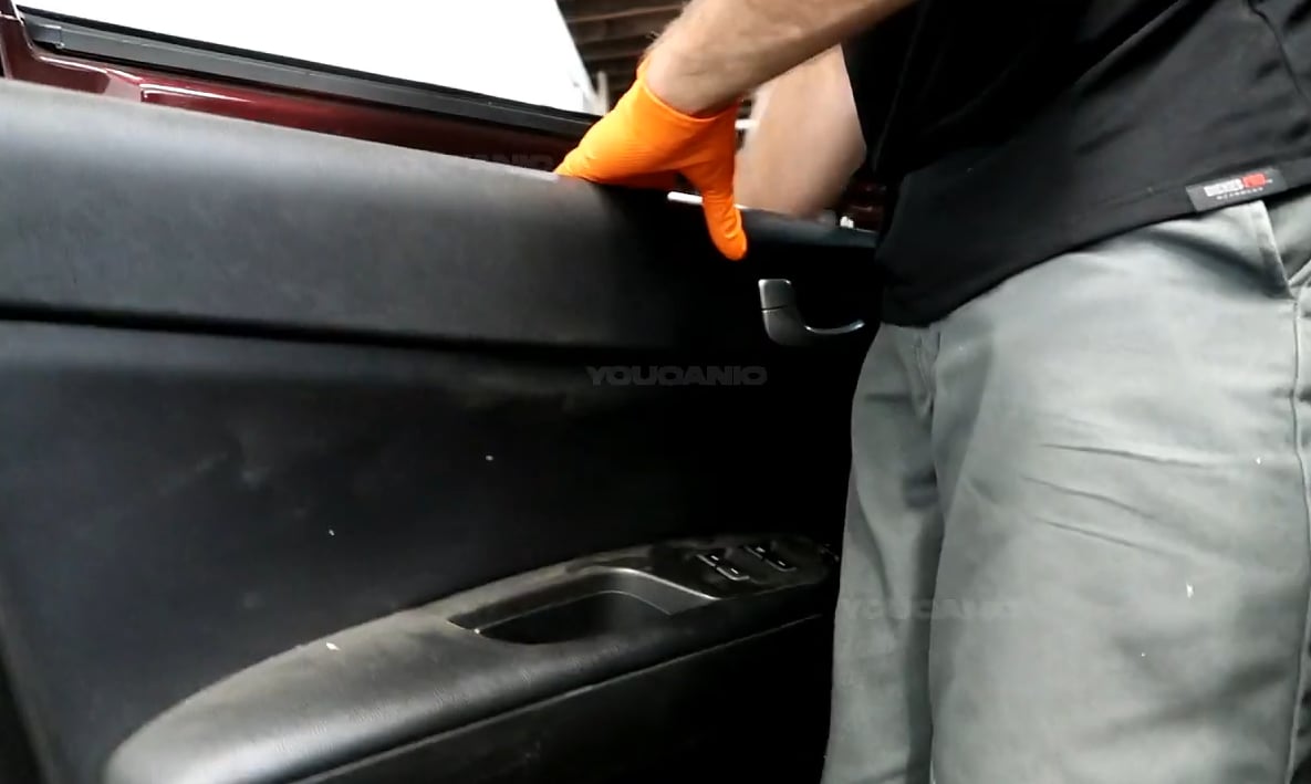 Removing the door panel of the 2016-2020 Kia Optima.