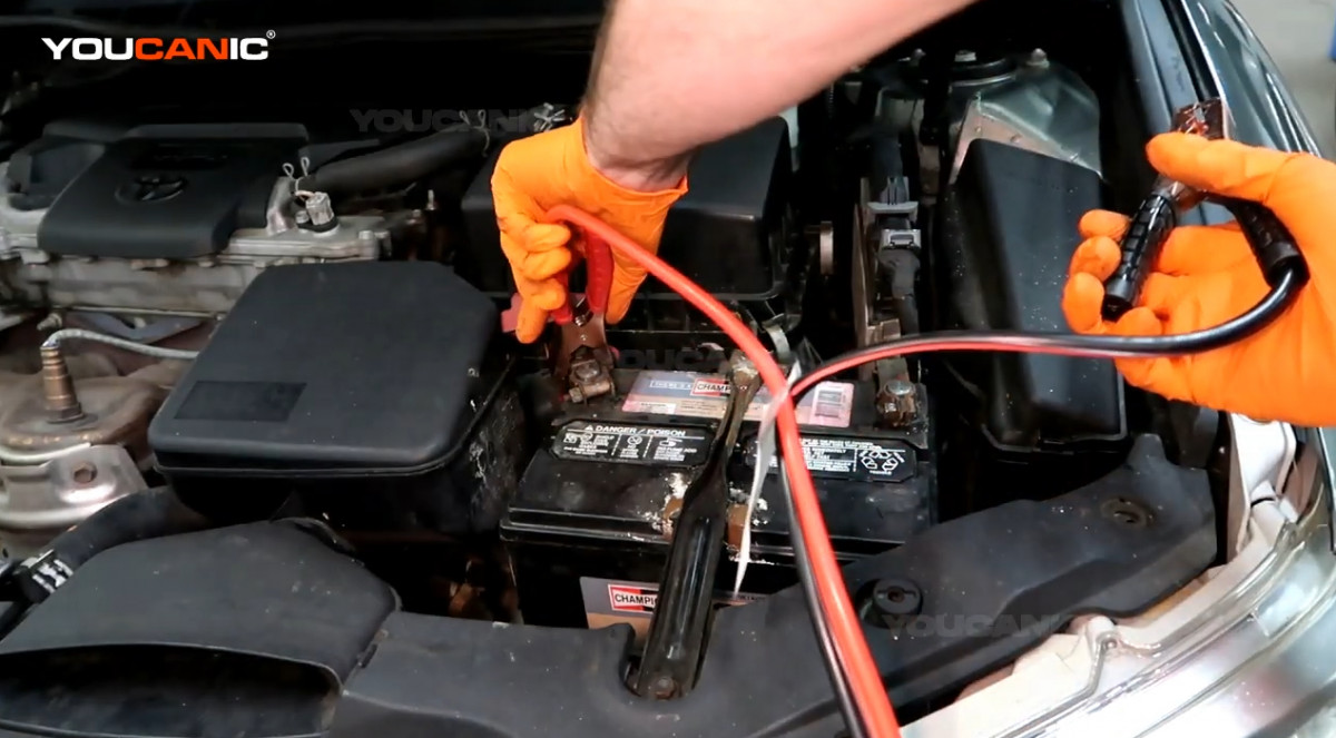 Connecting the red jumper cable to the positive terminal.