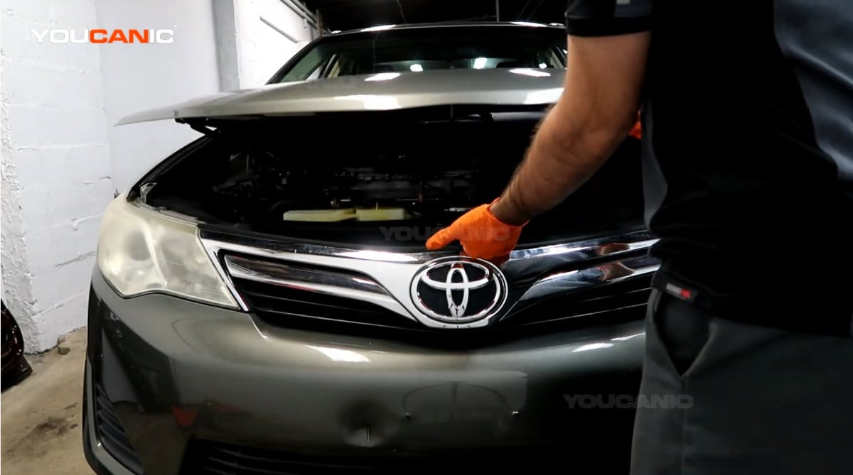 Pulling the hood of the Toyota Camry.