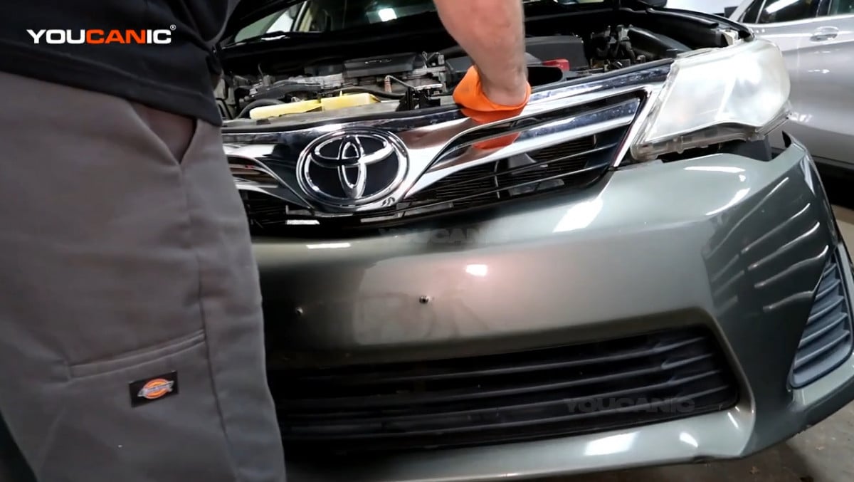 Removing the front bumper of the Toyota Camry.
