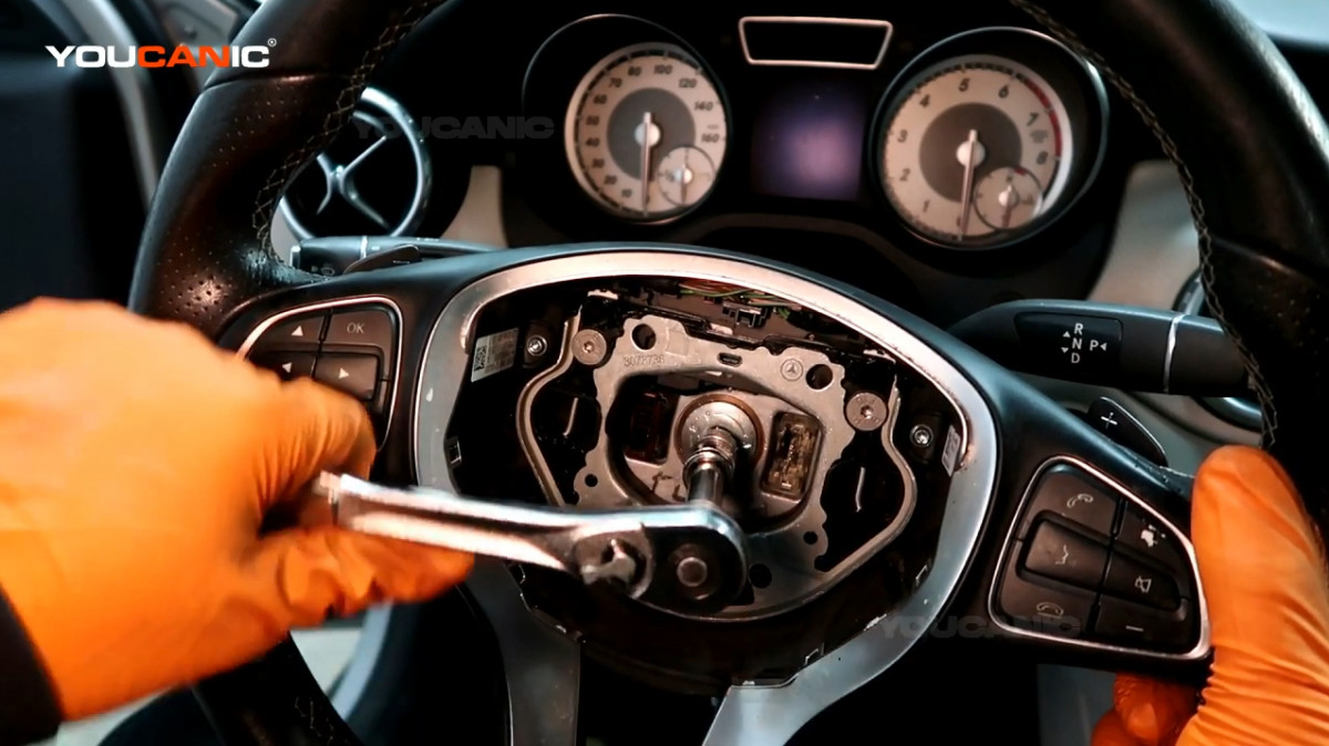 Loosening the center bolt on the steering wheel.