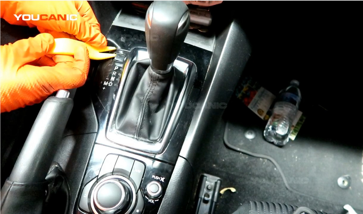 Removing the cover of the gear shift release button.