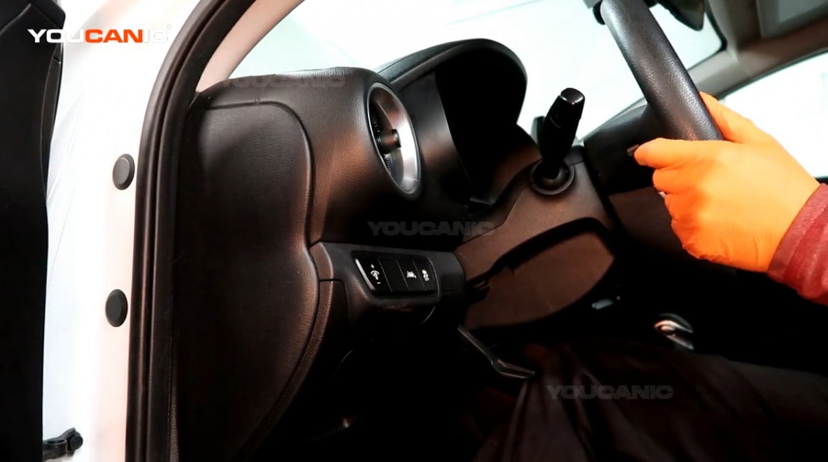 Adjusting the steering wheel of the Kia Forte.