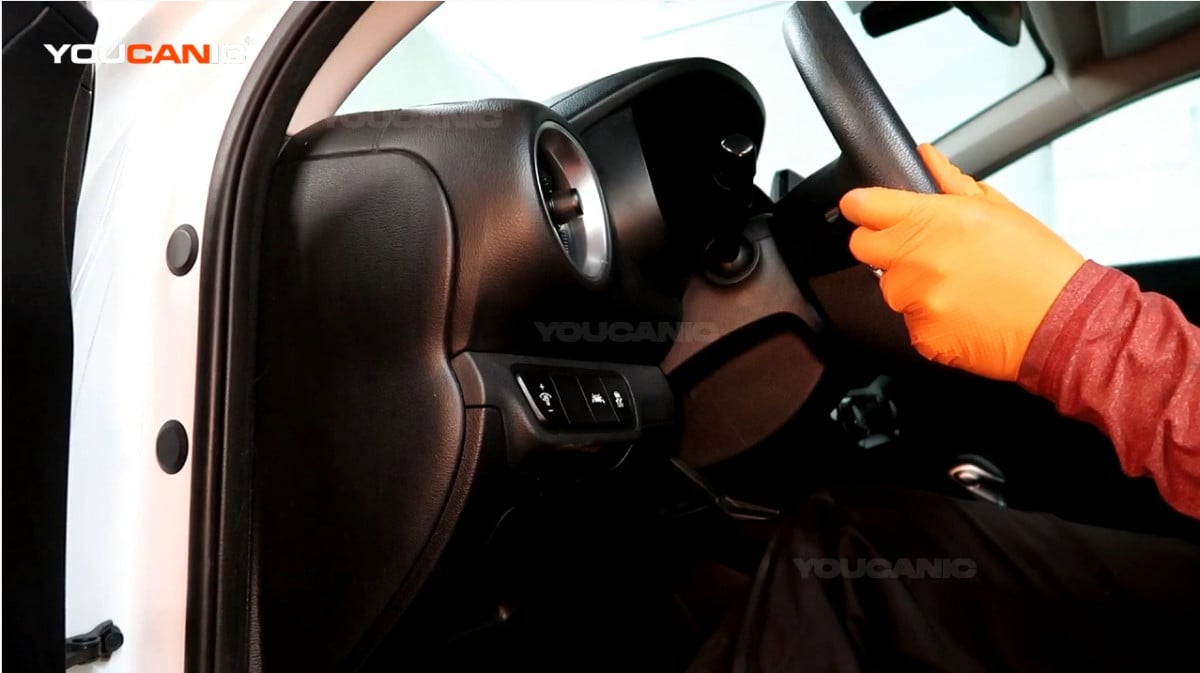 Adjusting the steering wheel of the Kia Forte.