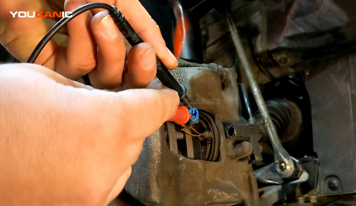 Connecting the probes of the tester into the brake pad wear sensor's connector.