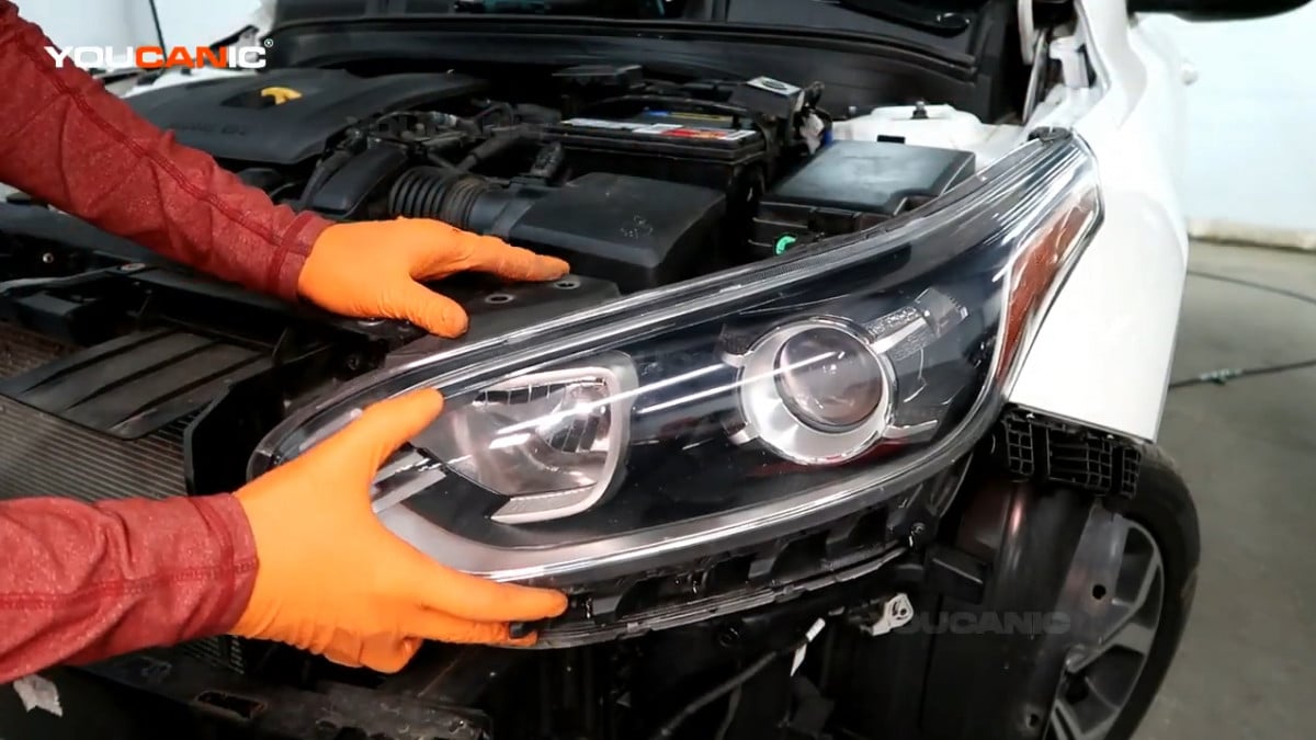 Installing the new headlight assembly of the Kia Forte.