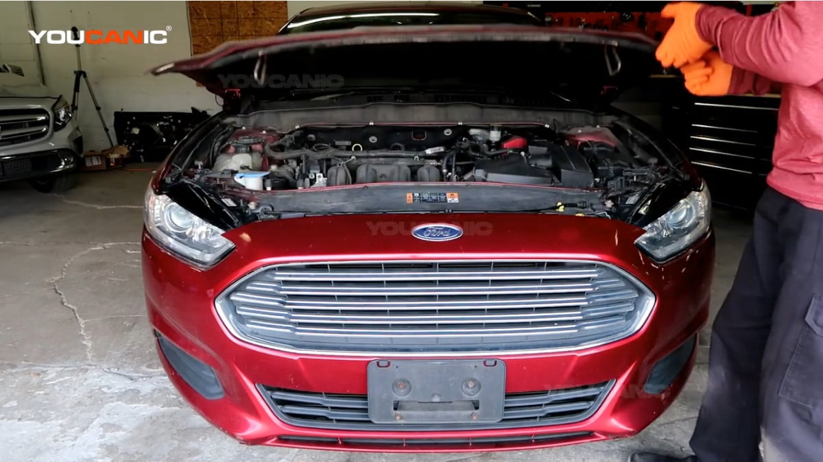 Opening the hood of the Ford Fusion.
