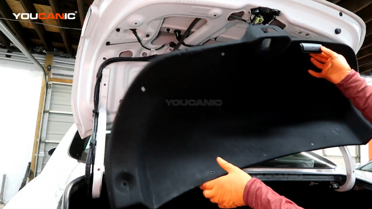 Removing the trunk shield of the Kia Forte.