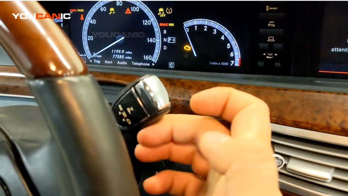 Pushing the gear shift toggle up to shift it to reverse.