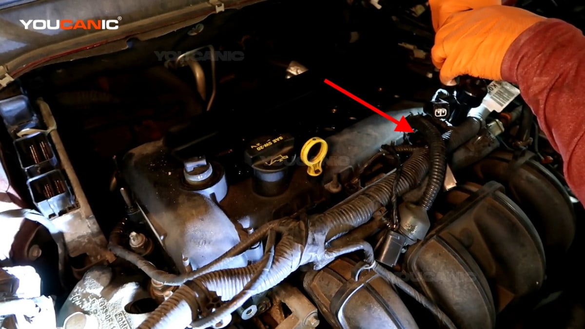 Removing the 10mm bolt on the knock sensor of the Ford Fusion.