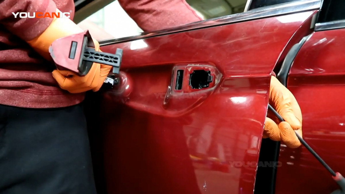 Removing the exterior door handle of the Ford Fusion.