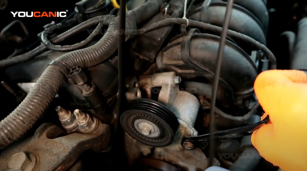Removing the serpentine belt of the Ford Fusion.