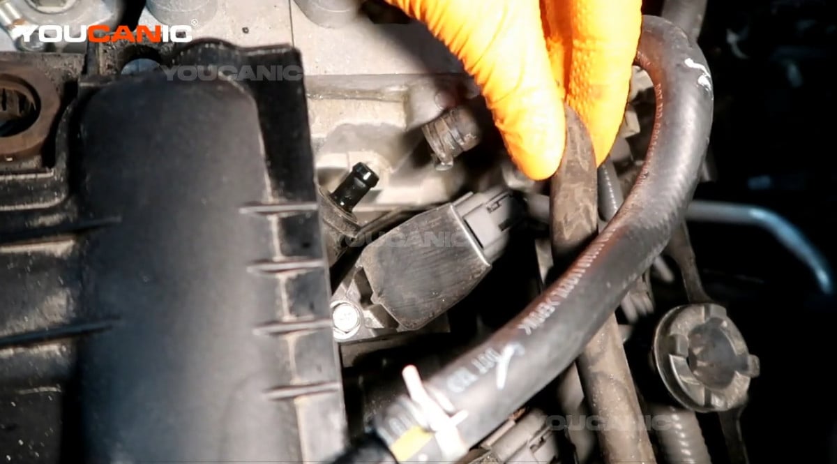 Detaching the hose above the ignition coil.