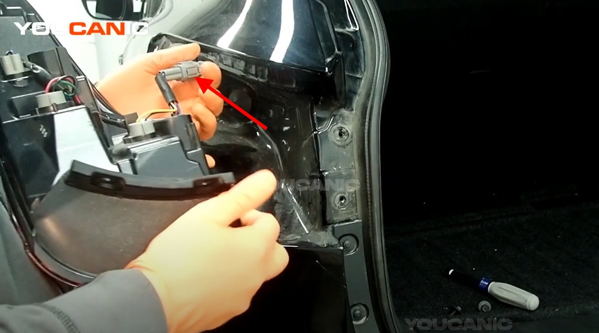 Disconnecting the electrical connector of the outer tail light assembly.