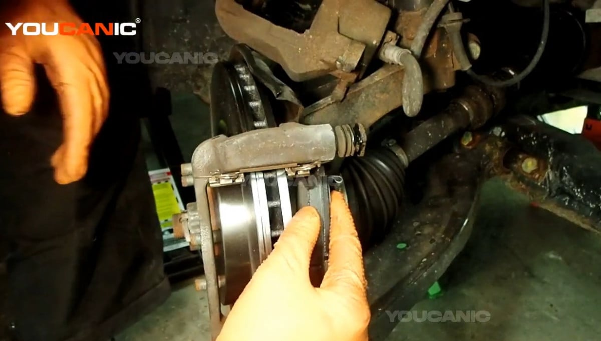 Installing the new front brake pads of the Nissan Rogue Sport.