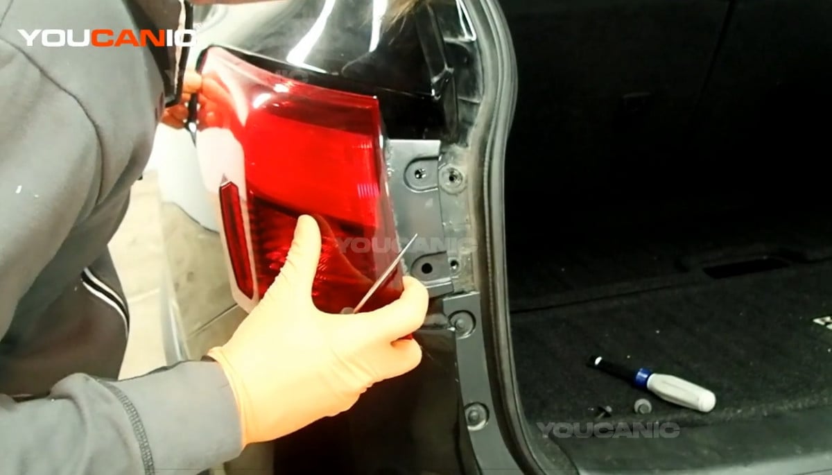 Reinstalling the outer tail light assembly of the Nissan Rogue.