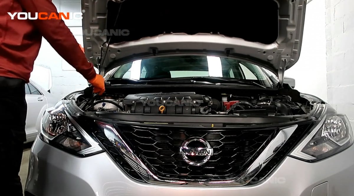 Opening the hood of the Nissan Sentra.