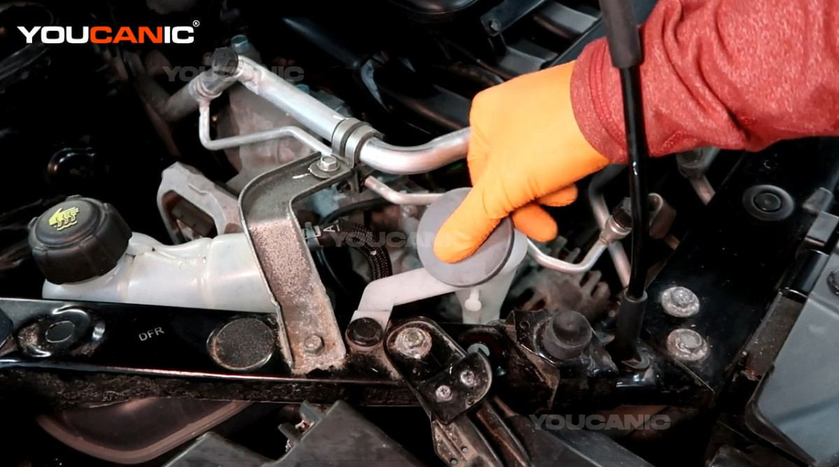 Opening the windshield washer reservoir of the Nissan Rogue Sport.