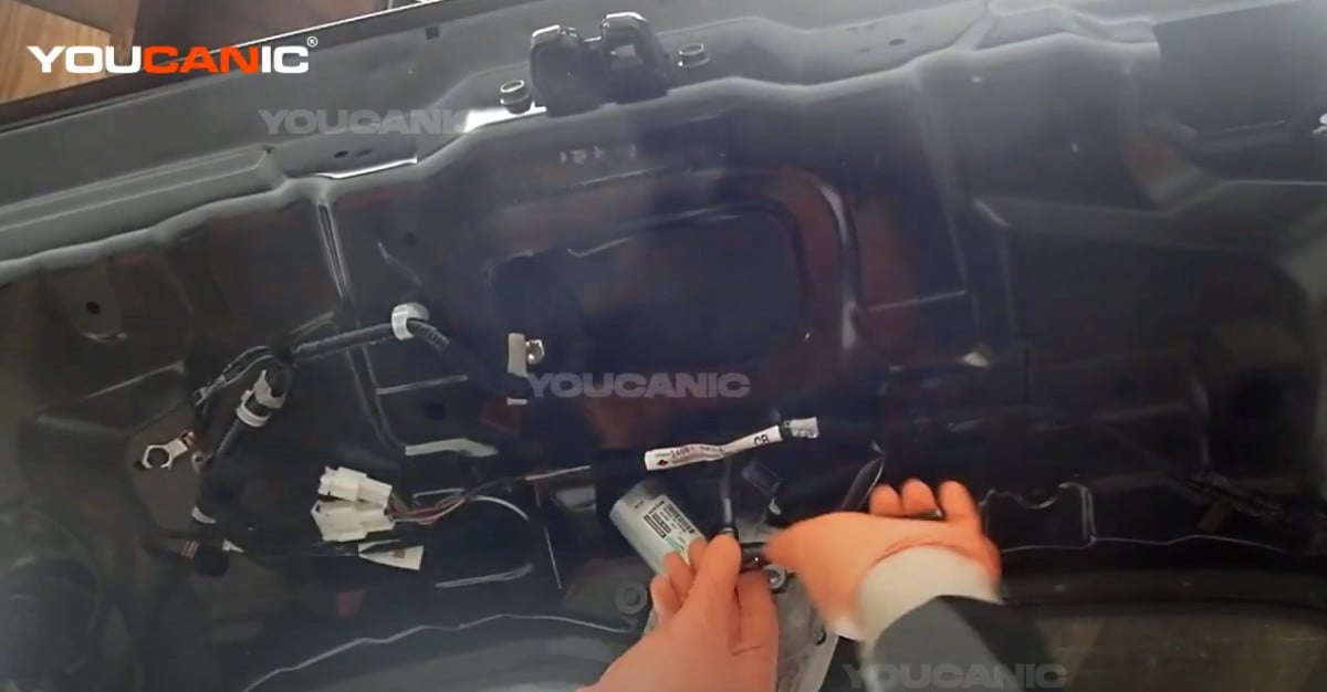 Removing the two 10mm bolts holding the backup camera.